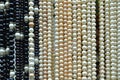 Black and white shiny pearl necklaces hanging at market for sle Royalty Free Stock Photo
