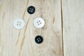 Black and white shirt buttons on wooden table Royalty Free Stock Photo