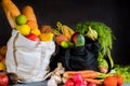 Black and white shopping bags with groceries on black background Royalty Free Stock Photo