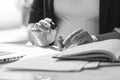 black and white shot of businesswoman painting fingernails at work