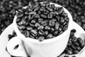 Black and white shot of a coffee cup full of coffee beans Royalty Free Stock Photo