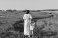 black and white shot of mother and daughter walking by rural road Royalty Free Stock Photo