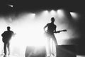 Black and white shot of rock band in a stage backlights Royalty Free Stock Photo