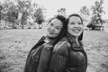 Black and white shot of two smiling chinese women leaning on their back Royalty Free Stock Photo