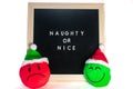A Sign That Says Naughty or Nice With Christmas Emoticons In Front of It