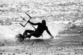 Black & white silhouette of backlit kiteboarder dragging his hand while speeding through Juan de Fuca Strait