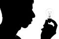 Black and white silhouette of head thoughtful man looking at a lamp in his hands, concept ideas,thought bulb Royalty Free Stock Photo