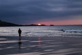 Silhouette of Man in Hoodie Walking Alone on Beach During Sunset Royalty Free Stock Photo