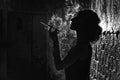 A Black and white silhouette portrait of a young woman smoking a cigarette in a mouthpiece. Royalty Free Stock Photo