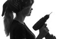 Black and white silhouette of a young woman construction worker in overalls with a screwdriver in his hands and goggles and Royalty Free Stock Photo