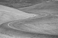 Black and white sinuous road in Z shape amidst treeless hills