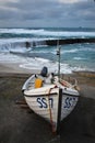 Small fishing boat and waves running over the Harbour walll - Sennen Cove Harbour Cornwall UK Royalty Free Stock Photo