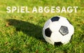 Black white soccer ball with grass german text spiel abgesagt, in english game canceled