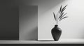 A black and white still life composition featuring a tall, slender vase with a plant and a rectangular block. Royalty Free Stock Photo