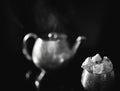 Black and white still life with an oriental tea party. Metal teapot and vase with patterns on a dark background. Royalty Free Stock Photo