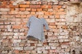 Black and white striped womens blouse hanging on a brick old wall outdoors