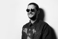 Black and white studio portrait of young smiling man, wearing sunglasses. Royalty Free Stock Photo