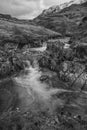 Black and white stunning landscape image of River Coe in Scottish Highlands with mountains in background Royalty Free Stock Photo