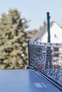 Black and white table tennis net from the side over blue outdoor plate, vertical photo