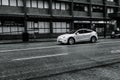 Black and White Tesla Model S Driving in Vancouver on a quiet, wet and grungy street