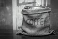Black & white tone color coffee sack on wooden table. Royalty Free Stock Photo