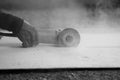 Black and white toned image of angle grinder cutting concrete with hands of heavy industry worker. Royalty Free Stock Photo