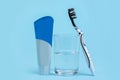 A black and white toothbrush with toothpaste and glass of mouthwash on blue background with copy space Royalty Free Stock Photo