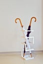 Black and white umbrella stand in a special geometric stand against white wall in the room
