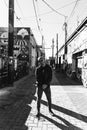 Portrait of Modern Young Person Hipster Guy Standing Alone in Urban Street Covered Colorful Graffiti Alleyway in Black and White Royalty Free Stock Photo