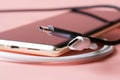 Black and white USB Type-C connectors next to a modern mobile phone on a pink background. Shallow depth of field. Selective focus Royalty Free Stock Photo