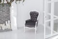 Black and white velours vintage armchair in minimalistic scandinavian room with brick fireplace and candles. horizontal