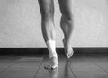 Black and white version of Athlete balancing on a recovering ankle sprain with an ankle tape job