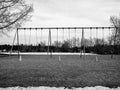 Black and white version of Closed school playground swings with orange pylon cones due to the covid 19 pandemic Royalty Free Stock Photo