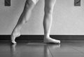 Black and white version of the hardworking disciplined ballerina ballet dancer warming up in her pointe shoes Royalty Free Stock Photo