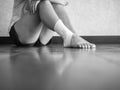 Black and white version of Injured athlete sitting on the sidelines due to ankle sprain