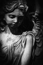 Black and white vertical image of sad angel of death. Fragment of an ancient statue