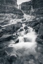 Black and white vertical long shutter shot of cascading waterfall from Canadian Rockies, Canada