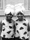 Black and white vertical photo of identical African-American girl twins disguised
