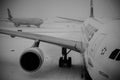 Black and White View of an Airplane Waiting for Passengers to Ãâoard. JFK Airport on a Snowy Day.