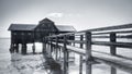 Black and white view of a boathouse at the Ammersee lake with a jetty next to it in Germany