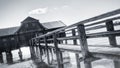 Black and white view of a boathouse at the Ammersee lake with a jetty next to it in Germany
