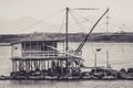 Black and white view of a flock of birds on a traditional trebuchet fishing hut in Marina di Pisa, Italy