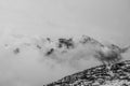 Black and white view of summit of Cima Undici emerging from the clouds Royalty Free Stock Photo