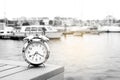 Vintage clock silver put on wood near port with background boat, sea and white sky in morning time, clock concept in holiday time Royalty Free Stock Photo