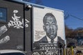 A black and white wall mural of John Lewis on the side of a brick building in Little Five Points surrounded by parked cars