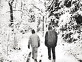 Black and white watercolor style of two people walking in the woods during a snowfall in the north of Scandinavia