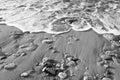 Black & White - Wave of the sea on the beach with sand and stone Royalty Free Stock Photo