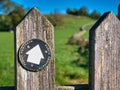 A black and white way marker on a weathered wooden gate points the way on a route through the Peak District in Derbyshire, UK. Royalty Free Stock Photo