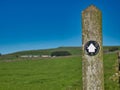 A black and white way marker on a weathered wooden post points the way on a route through the Peak District in Derbyshire, UK. Royalty Free Stock Photo
