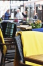 Outside patio of an european restaurant - tables and black- brown chairs with yellow blankets for cold weather Royalty Free Stock Photo